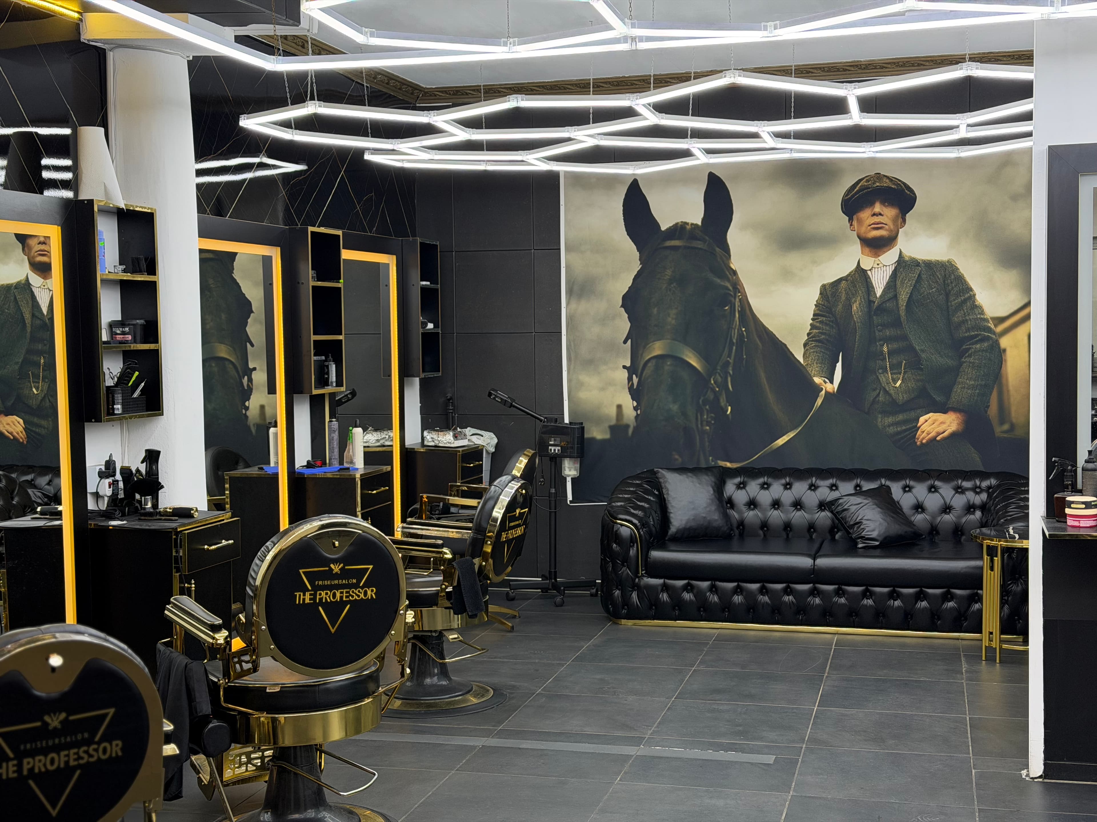 Salon-Übersicht: Barbierstühle, Spiegel und Peaky-Blinders-Wandbild bei The Professor